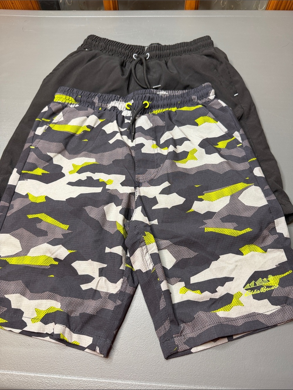 Kid’s Eddie Bauer shorts bundle. Black & Lime Camo and solid black. Size: 7-8